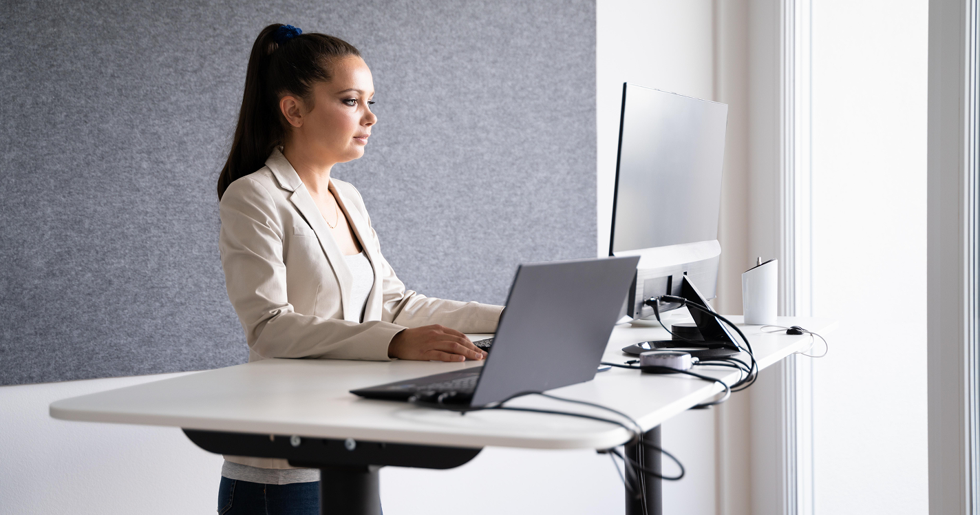 Office worker using a laptop at a standing desk