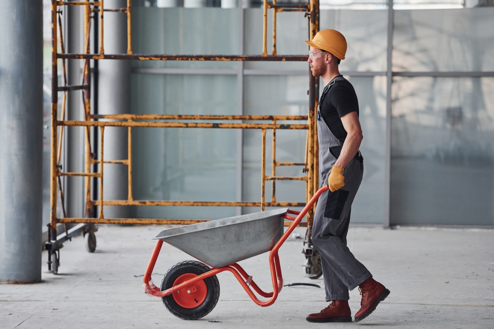 Construction worker pushing a wheelbarrow on site