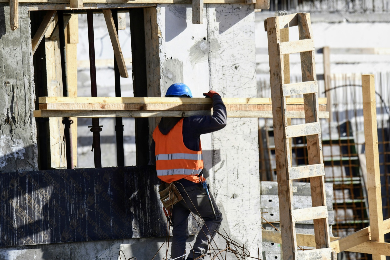 Construction worker carrying materials on a building site
